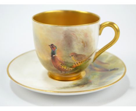 A Royal Worcester cup and saucer hand painted by James Stinton and decorated with pheasants in a landscape, puce printed mark