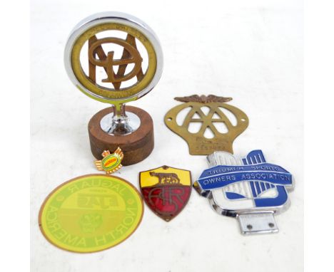 A 'Triumph Sports Owners' Association' badge, a brass 'AA' example, a 'Daimler' hood ornament, an enamel detailed 'ASR' plaqu
