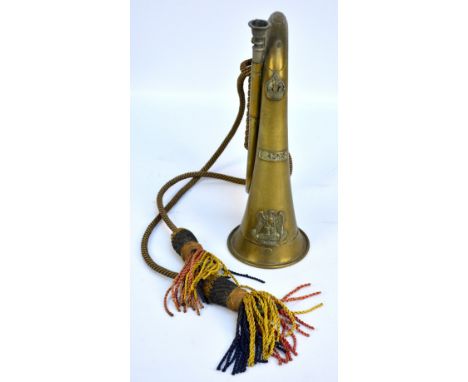 A regimental bugle with cord and tassels for Royal Scots Greys, impressed to body 'Ypres 1914 15'.   CONDITION REPORT:  Dents