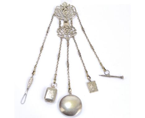 A silver plated pierced chatelaine with two pierced scrolling foliate plates with hook to the back, with five fancy chains su