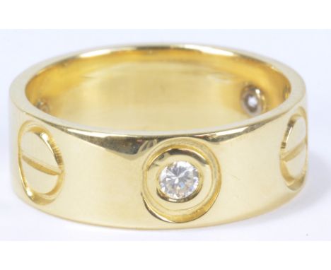 A Cartier style 18ct yellow gold ring set with three diamonds interspersed by three 'screw heads', size K, approx 5.8g.