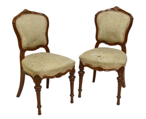A pair of late 19th century walnut salon chairs with padded backs, stuffover seats and fluted ring turned front legs.