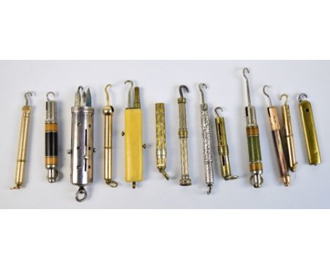 A collection of small propelling button hooks, including brass, white  metal, wood examples, etc, and a steel four piece prop