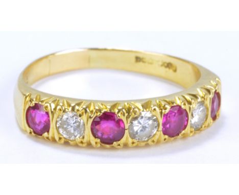 An 18ct yellow gold ruby and diamond seven stone ring, the four round brilliant cut rubies totalling approx 1ct, interspersed