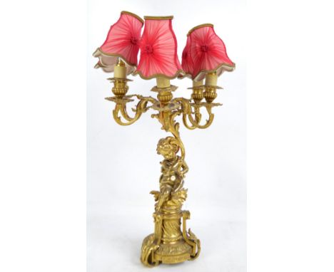 A late 19th century gilt metal five branch candelabrum with figural cherubic stem above decorative circular base, height 55cm