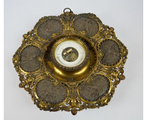 An unusual late 19th century French gilt spelter barometer, the frame with six panels depicting cherubs within a pierced orna