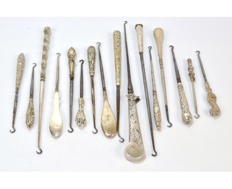 A quantity of white metal button hooks with sheath handles, including an engine turned example, tapering examples decorated w