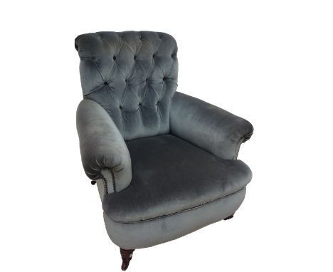 A late Victorian pale blue button upholstered arm chair raised on ring turned front legs.