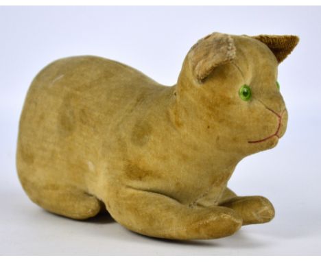 An early 20th century velveteen cat with green glass eyes and stitched nose and mouth, length 19cm, possibly Steiff, no label