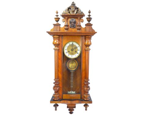 A late 19th/early 20th century walnut Vienna wall clock, the pediment with applied carved female bust decoration above circul