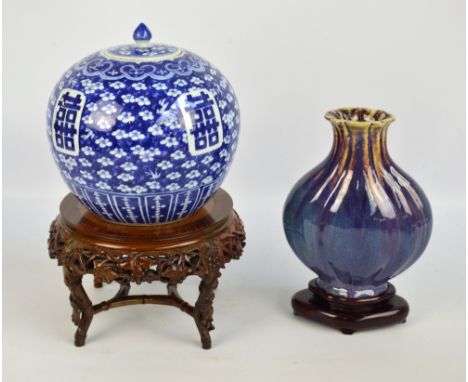 An early 20th century Chinese globular jar and cover painted underglaze blue with auspicious character marks on prunus ground