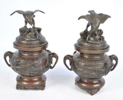 A pair of Japanese Meiji period bronzed koro and covers surmounted with eagles and snakes and with elephant trunk handles, he