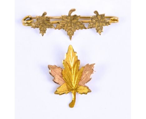A 10ct yellow gold bar brooch decorated with three maple leaves, length 3.5cm, and a further single leaf two-tone gold exampl