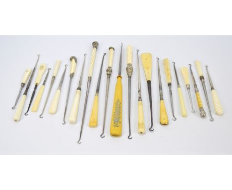 A collection of button hooks with ivory, faux ivory, and bone handles, some with hallmarked silver mounts, of various shapes 