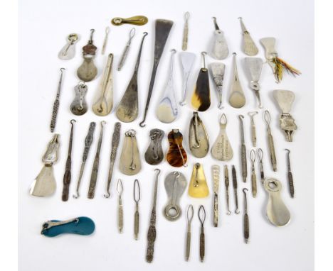 A collection of combination button hook and shoe horn including straight examples, folding examples, mostly steel, and a quan