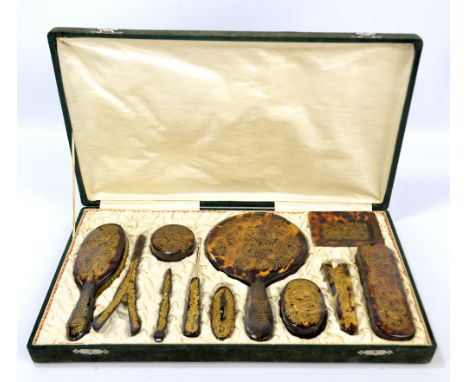 A cased Xlonite (faux tortoiseshell) dressing table set, decorated with gilt dragon motifs, comprising hand mirror, hand brus