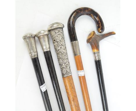 A tortoiseshell handled malacca shafted walking stick with silver collar, an antler handled ebonised walking stick and three 