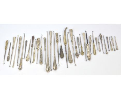 A quantity of white metal, silver plated, and other metal button hooks, many with sheath handles, including examples by WMF, 