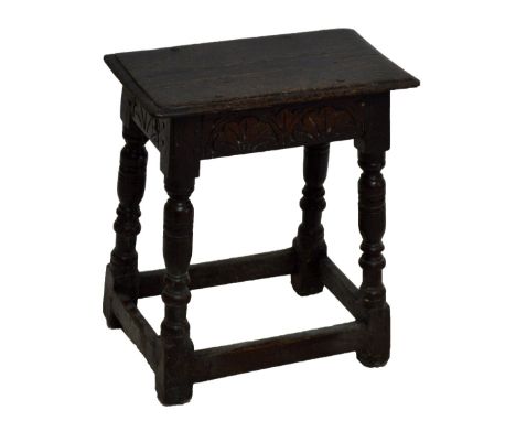 An 18th century oak joint stool with carved frieze and ring turned and block legs united by stretchers, the top 49.5 x 28cm.