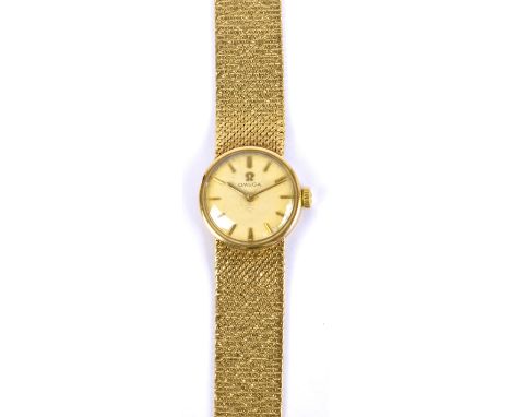 OMEGA; a lady's vintage 9ct gold wrist watch with circular dial set with gold baton markers and with textured integral bracel