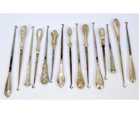 Fifteen medium sized button hooks with hallmarked silver sheath handles, including a floral iris example with monogrammed car