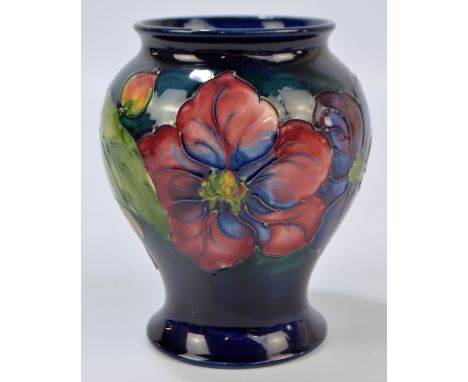 MOORCROFT; a 'Clematis' pattern tubeline decorated baluster vase on dark blue ground with Walter Moorcroft signature and impr