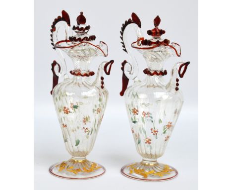 A pair of small contemporary Milanese glass ewers with applied ruby detail, painted decoration and wrythen moulded foot, each