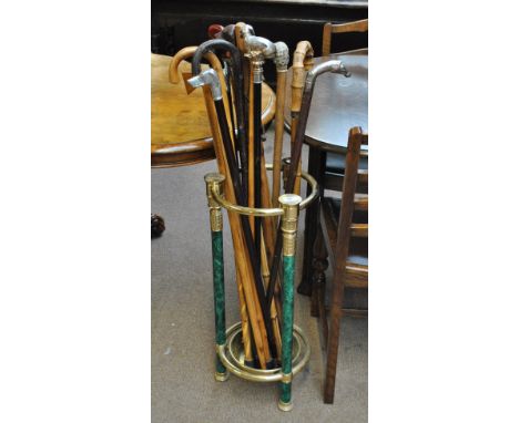 A simulated malachite and brass mounted circular stick stand containing a quantity of decorative modern walking sticks.