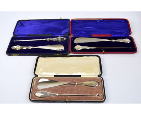 A cased George V hallmarked silver heath handled set of shoe horn and button hook of squared form with floral motifs, Crisfor