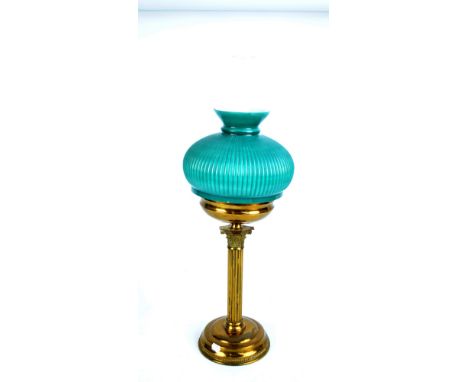 A vintage brass Corinthian column oil lamp with associated ribbed shade, height including chimney 73cm.