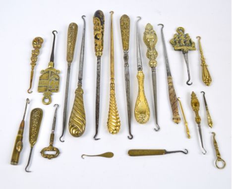 A small collection of brass handled button hooks including brass and wood example, an example made from a bullet casing, an e