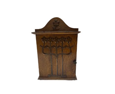 Art Nouveau oak wall cabinet, the hinged door and pediment applied with stylized copper flowers, H43cm x W29.5cm