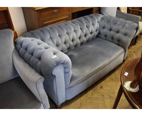 A two seater blue velvet chesterfield style sofa