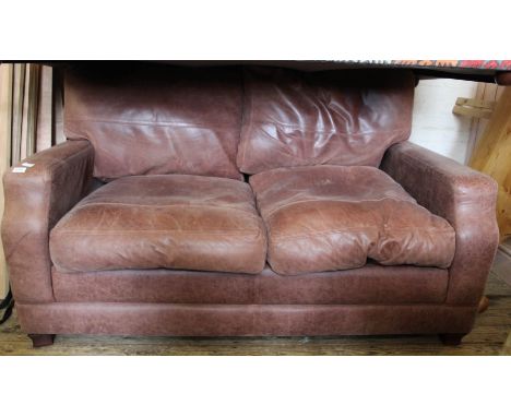 A brown leather two seater sofa