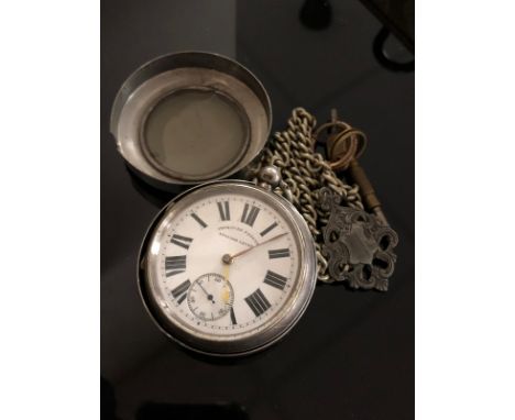 A silver English lever pocket watch suspended on white metal chain, with fob and key 