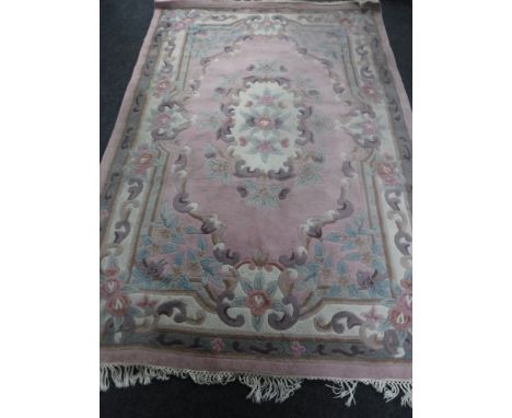 A pink Chinese fringed carpet, 273cm by 179cm