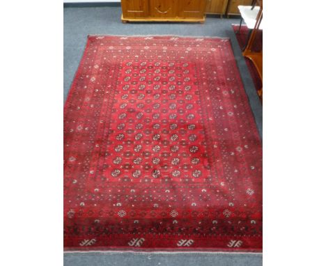 A Bokhara carpet on red ground, Afghanistan, 285cm by 206cm 