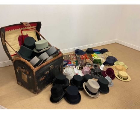 A dome top trunk with leather trim and interior tray full of vintage man's and lady's hats, scarves and accessories.