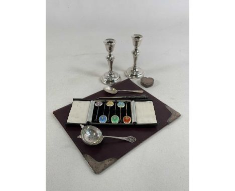 A group of small silver including a pair of loaded candlesticks, heart shaped trinket box, sifting spoon, teaspoon, notepad, 