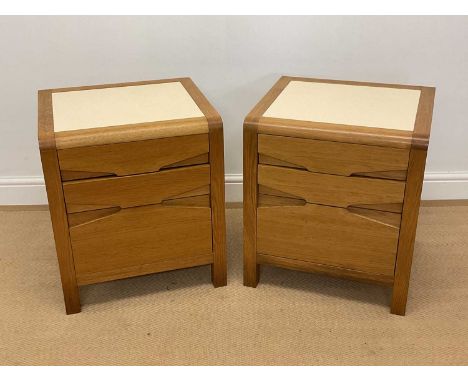 A pair of light oak bedside tables with three drawers and Formica top, height 56cm, width 50cm, depth 45cm.