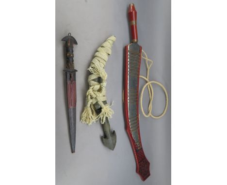 A SOUTHEAST ASIAN SHORTSWORD AND TWO AFRICAN DAGGERS^ 20TH CENTURY¦the first with curved single-edged blade^ hardwood grip^ i