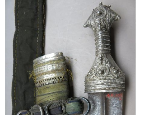 ‡ AN ARAB DAGGER (JAMBIYA)^ LATE 19TH/20TH CENTURY¦with curved double-edged blade formed with a medial ridge^ silver-encased 