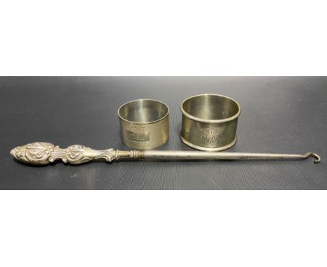 Two silver hallmarked napkin rings together with a silver handled button hook, weight of napkin rings 1.60oz approx.