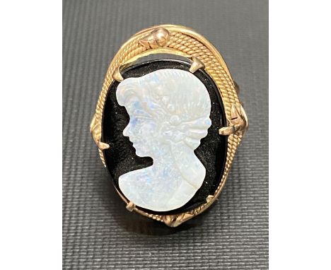 Israeli 14ct gold ring set with oval onyx and applied with an opal profile portrait of a woman, the ring shank with three wir