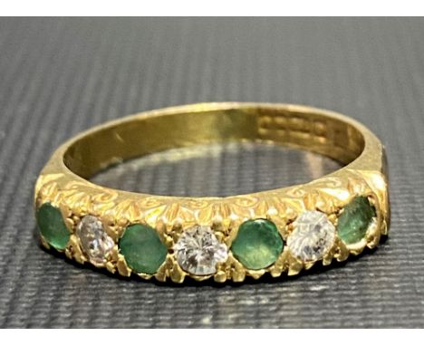 A 18ct hallmarked gold diamond and emerald seven stone set half eternity ring, the three diamonds each of 0.07ct spread appro