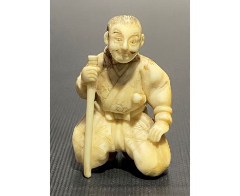 Meiji period ivory carved netsuke in the form of a kneeling gentleman with stick, height 4cm