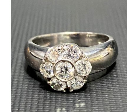 A modern 18ct white gold diamond cluster daisy ring, the central diamond of 0.20ct spread approx, the six smaller diamonds of