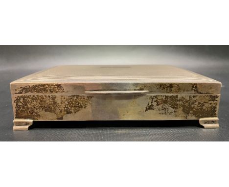 Modern silver rectangular engine turned cigarette box raised on four bracket feet, maker H.Bros, Birmingham 1965.