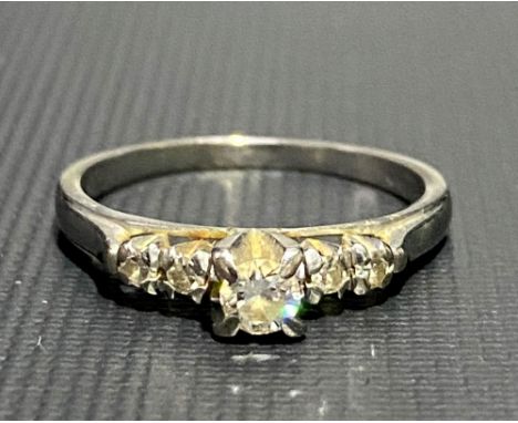 An 18ct white gold diamond set five stone ring, the central diamond of 0.20ct spread approx. and flanked by four small diamon