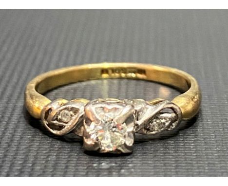 18ct gold diamond set ring with central diamond of 0.20ct spread approx, the stone flanked by two small diamonds, weight 3.2g